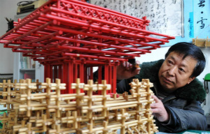 魏清发展示他所创作的秸杆扎编工艺品