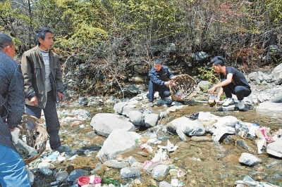 吴华(中)带领村民清理河道中的垃圾。.jpg