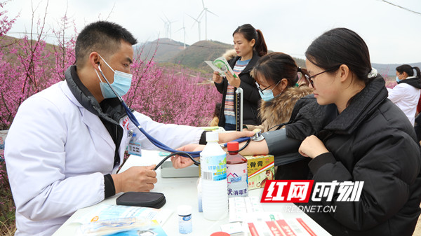 3月3日，江永县松柏瑶族乡花楼村，医务人员在义诊服务点为游客看病。.jpg